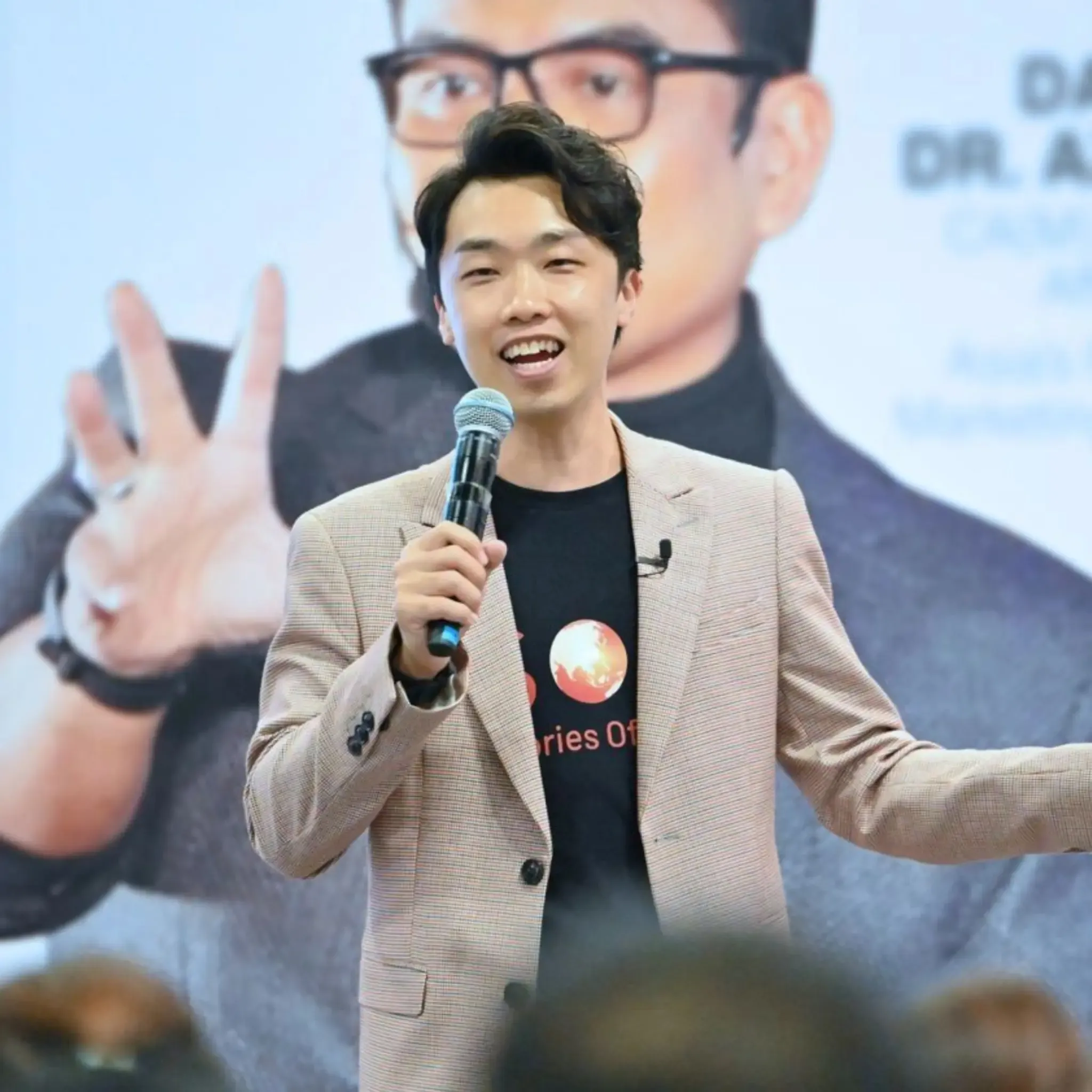 Sam Neo speaking on stage during a workshop.
