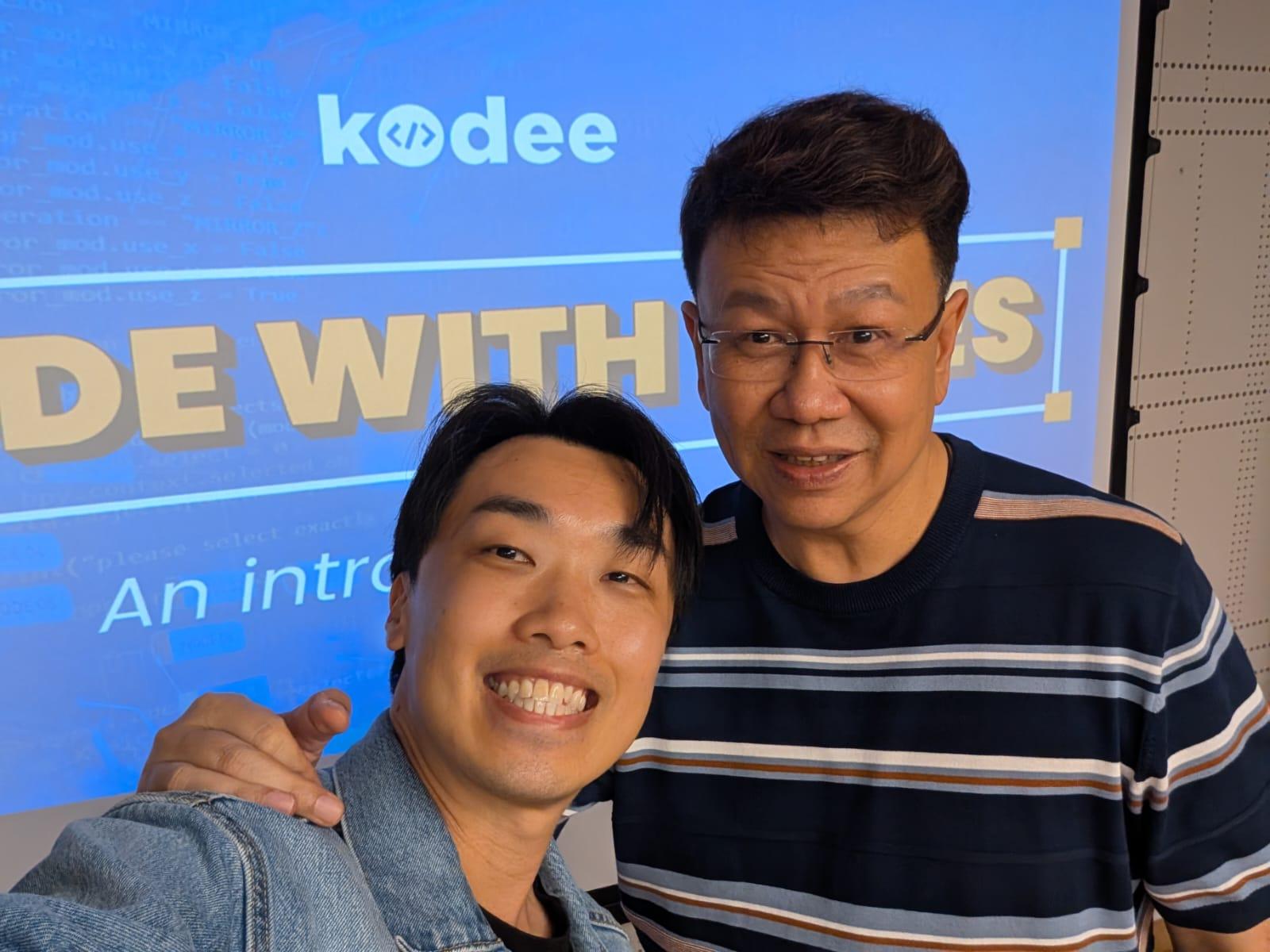 Sam Neo with a workshop attendee in front of the Kodee screen.