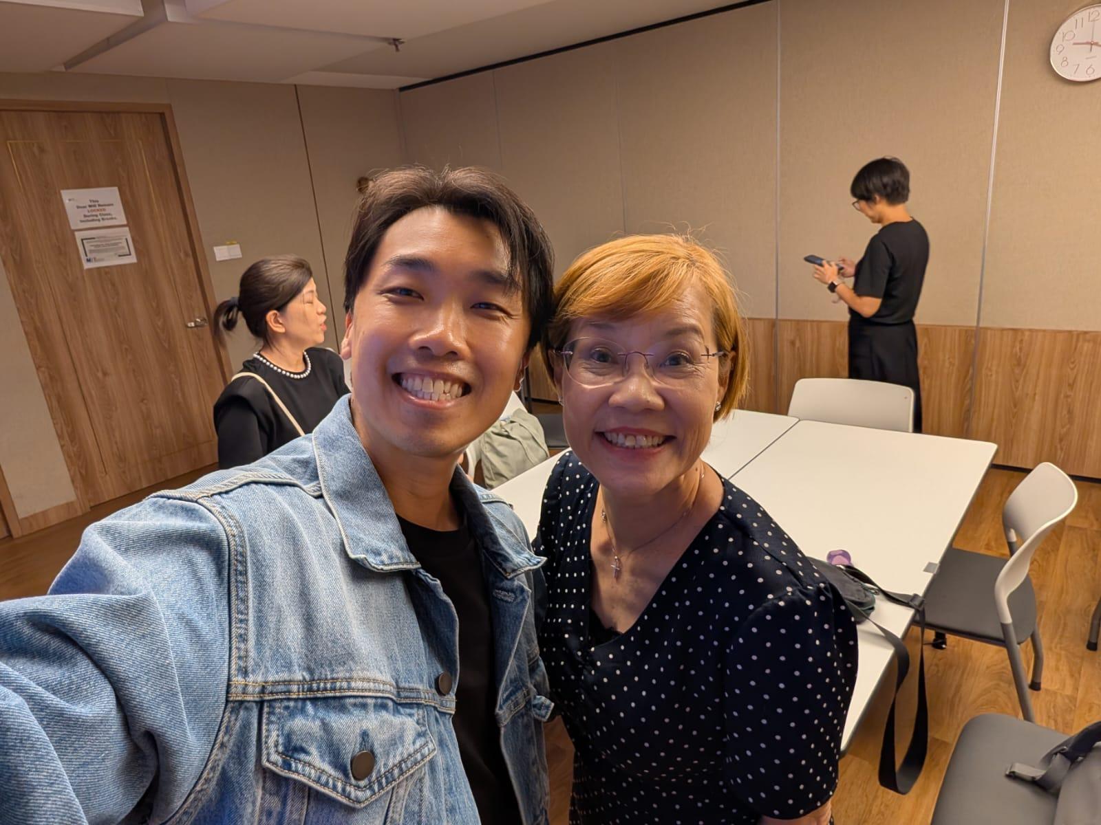 Sam Neo smiling with a workshop attendee during the event.